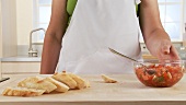 Preparing bruschetta: ciabatta, tomatoes and basil and an oven rack