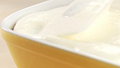 Preparing tiramisu: covering the second layer with mascarpone cream
