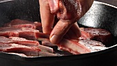 Lam chops being placed in a pan