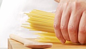 Spaghetti in einen Kochtopf geben