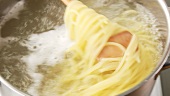 Spaghetti being stirred in a pot