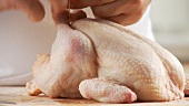 Chicken legs being tied together with kitchen twine