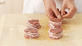 Mit Bacon umwickelte Filetscheiben mit Küchengarn festbinden