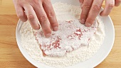 Dusting a seasoned escalope in flour