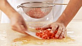 Diced tomato being drained in a sieve