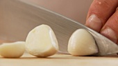Garlic cloves being halved