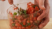 Basil and tomatoes being mixed together