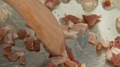 Diced bacon being fried