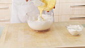 Egg yolk cream being added to beaten egg white