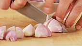 Peeled shallots being quartered