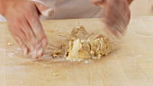 Shortcrust pastry being kneaded and dusted with flour