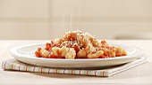 Gnocchi mit Tomatensauce und mit Parmesan bestreuen