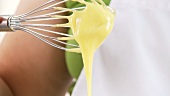 A whisk with mayonnaise