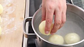 Kartoffelknödel ins kochende Salzwasser geben