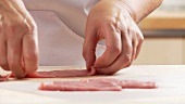 Veal escalope being tenderized with the balls of the hand