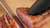 Slicing fried duck breast