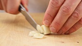 Garlic cloves being finely sliced