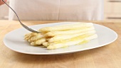 White asparagus being drizzled with melted butter
