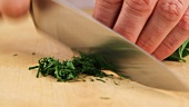 Dill and parsley being chopped