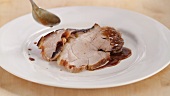 Roast pork with gravy being prepared (German Voice Over)