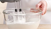 Egg white being beaten with a hand mixer