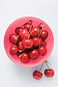 Fresh cherries in a pink bowl