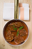 Braised venison escalopes with sauce in a pan