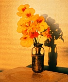 Gelbrote Kapuzinerkresseblüten in einer Vase auf dem Tisch