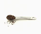 A Metal Measuring Spoon Full Of Caraway Seeds