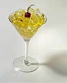 Geleewürfel mit einer Kirsche im Cocktailglas