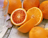 Orangen- und Blutorangenhälfte, Messer, leeres Glas, Orangen