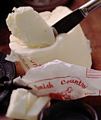 A Knife Slicing a Piece of Danish Country Butter