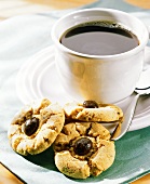 Eine Tasse schwarzer Kaffee mit drei Keksen