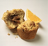 Muffin mit Feigenfüllung, halbiert, und ein Orangenschnitz