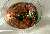 Marinated Pork Tenderloin in a Glass Bowl with Plastic Wrap