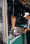 Mann verkauft Döner Kebab auf einem Marktstand