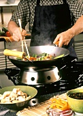 Person Stir Frying Vegetables and Chicken