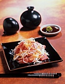 Sashimi Salat auf schwarzem Teller