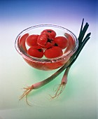 Fresh Tomatoes in a Bowl of Water; Scallions