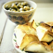 Teigtäschchen mit Spinat-Oliven-Füllung auf Teller
