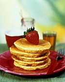 A Stack of Oatmeal Pancakes with a Strawberry