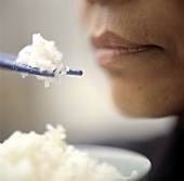 Asiatin mit einem Schälchen Reis und Reis auf Stäbchen