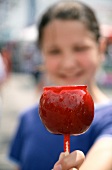 Red Candy Apple in the Hand of Smiling Girl at Fair