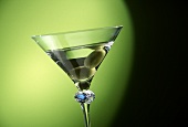 Glass of Martini with two olives, green background (detail)