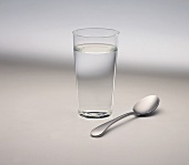 A glass of water and a spoon
