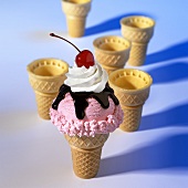 Strawberry ice cream in cornet with fudge and cream