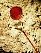 Ein Glas Rotwein auf Steinboden