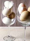 White and brown eggs in wine glasses
