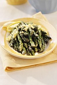 Steamed green asparagus on yellow plate