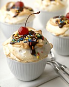 Ice cream with meringue, chocolate sauce, sprinkles & cherry